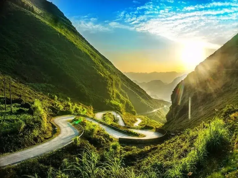 The winding road of Ma Pi Leng Pass at sunset, one of the most dangerous and beautiful mountain passes on the Ha Giang Loop, Vietnam.